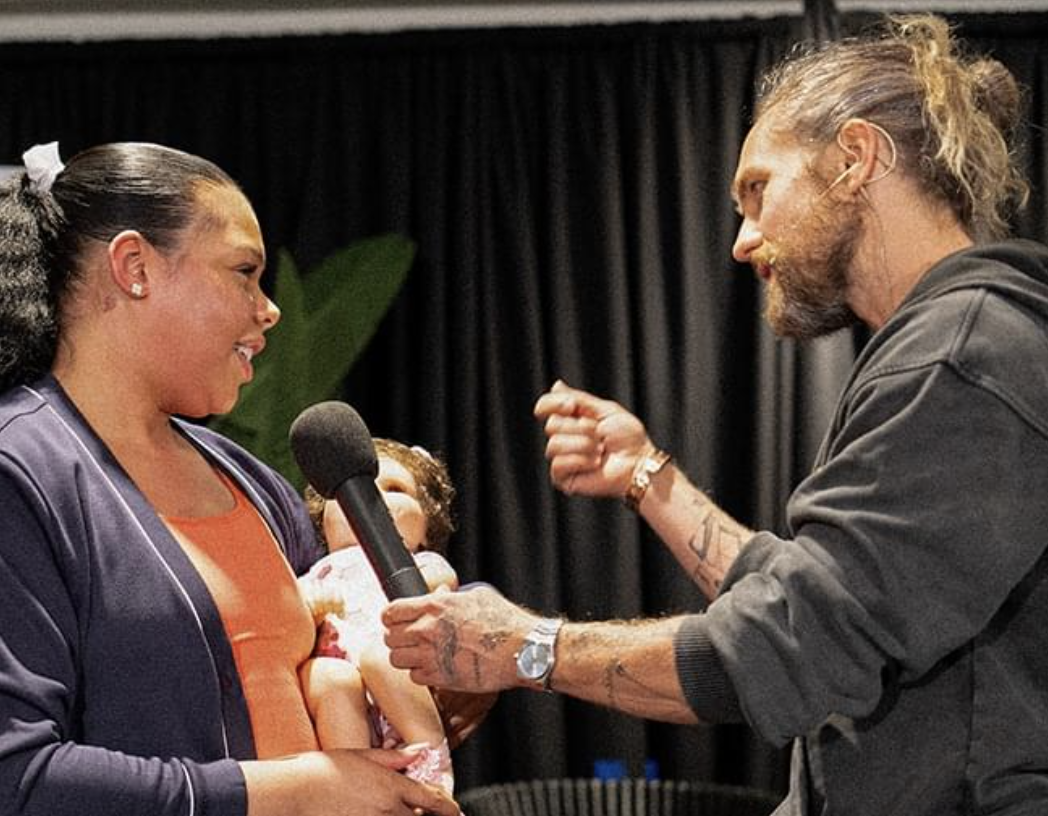 Aaron coaching a participant on stage